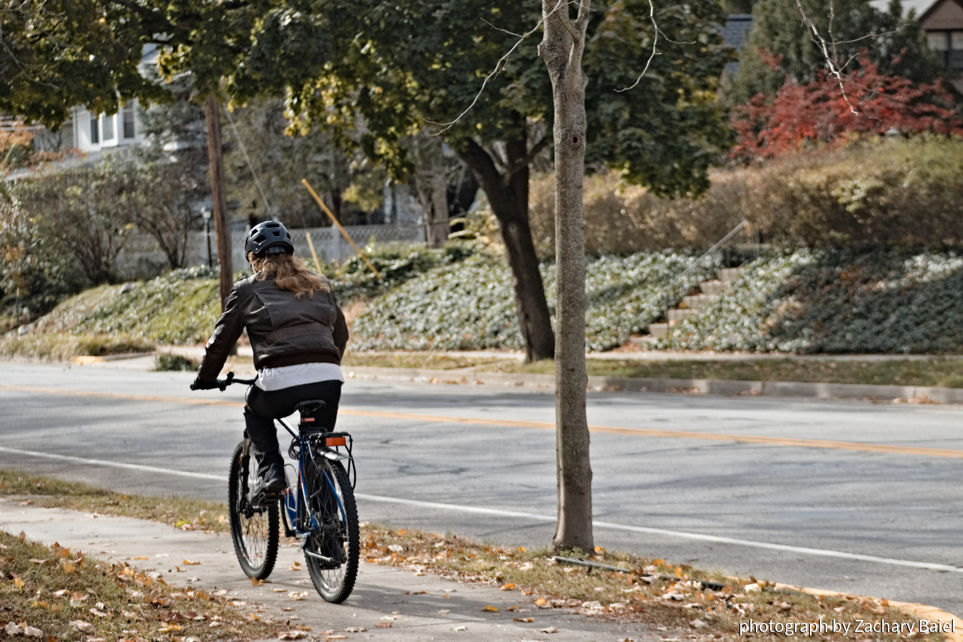 A cyclist riding on the sidewalk along Salisbury Street | West Lafayette, Indiana | November 2022