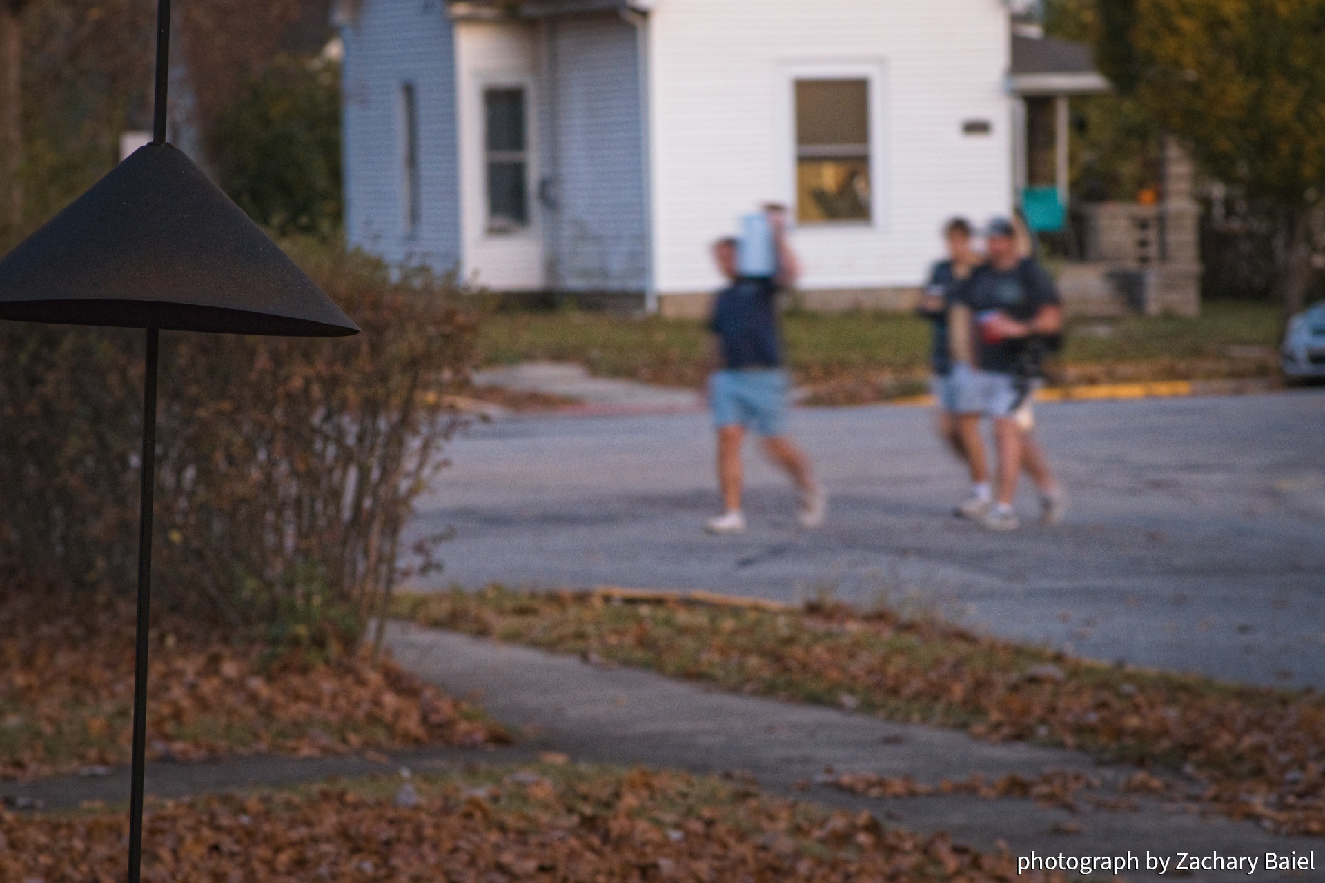 A group of students walking, carrying a case of beer on their shoulder | November 2022